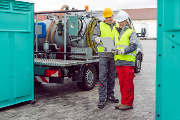 workers doing some logistics in the rental toilet business looking at clipboard